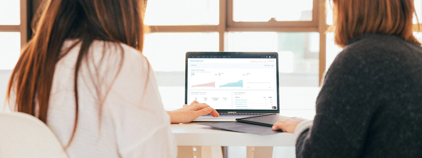 a man and a womans hand on a laptop displaying Hubspot